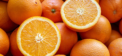 Pile of Valencia oranges, with one cut into two halves