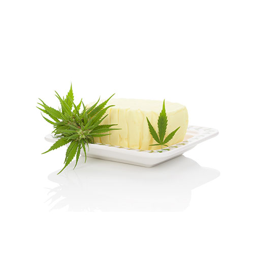 Stick of cannabis butter on a white plate with cannabis leaves surrounding it