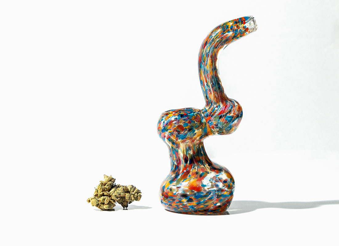 Colorful bubbler pipe next to a bud of flower