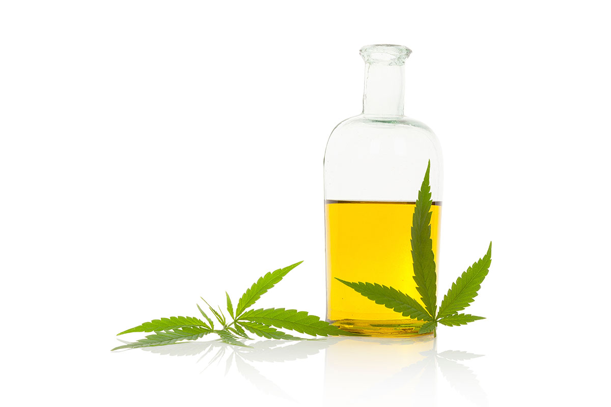 Cannabis cooking oil in a clear bottle with cannabis leaves at the base