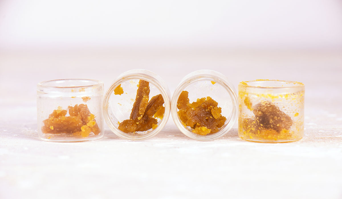 Four containers with cannabis crumble inside each