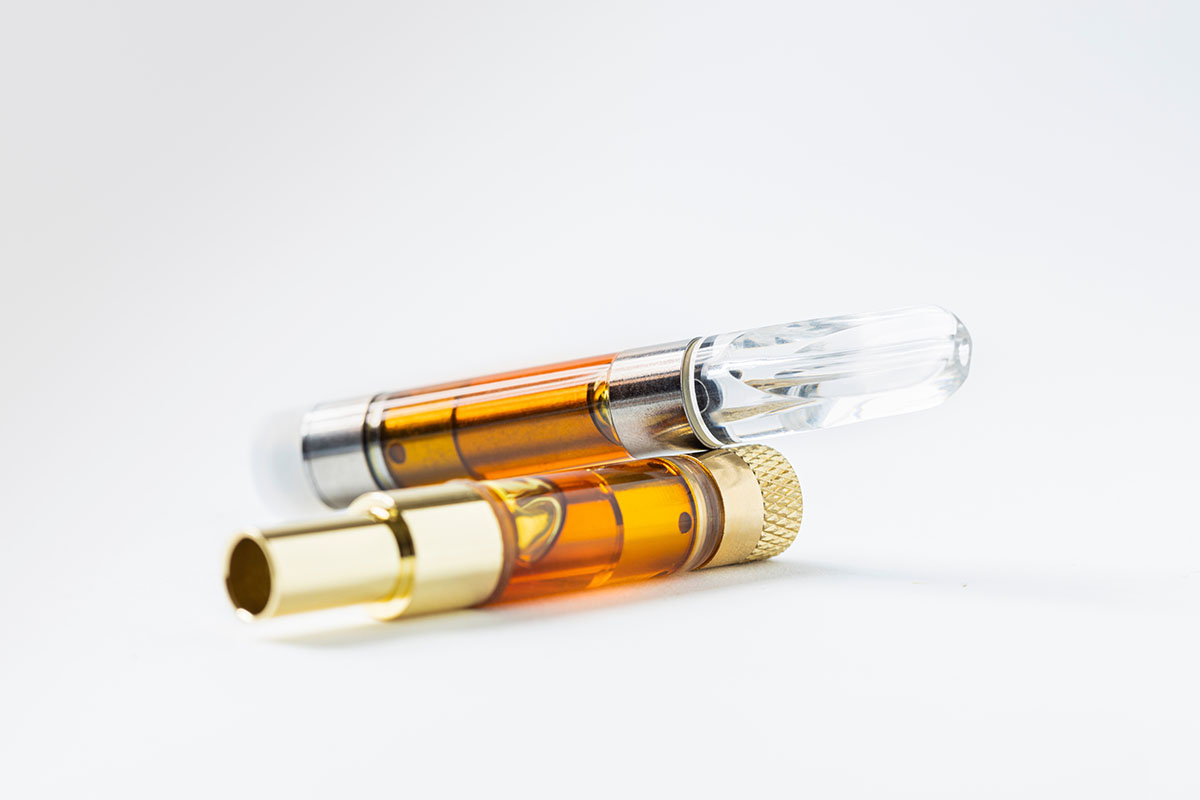 Two vape cartridges on a white background