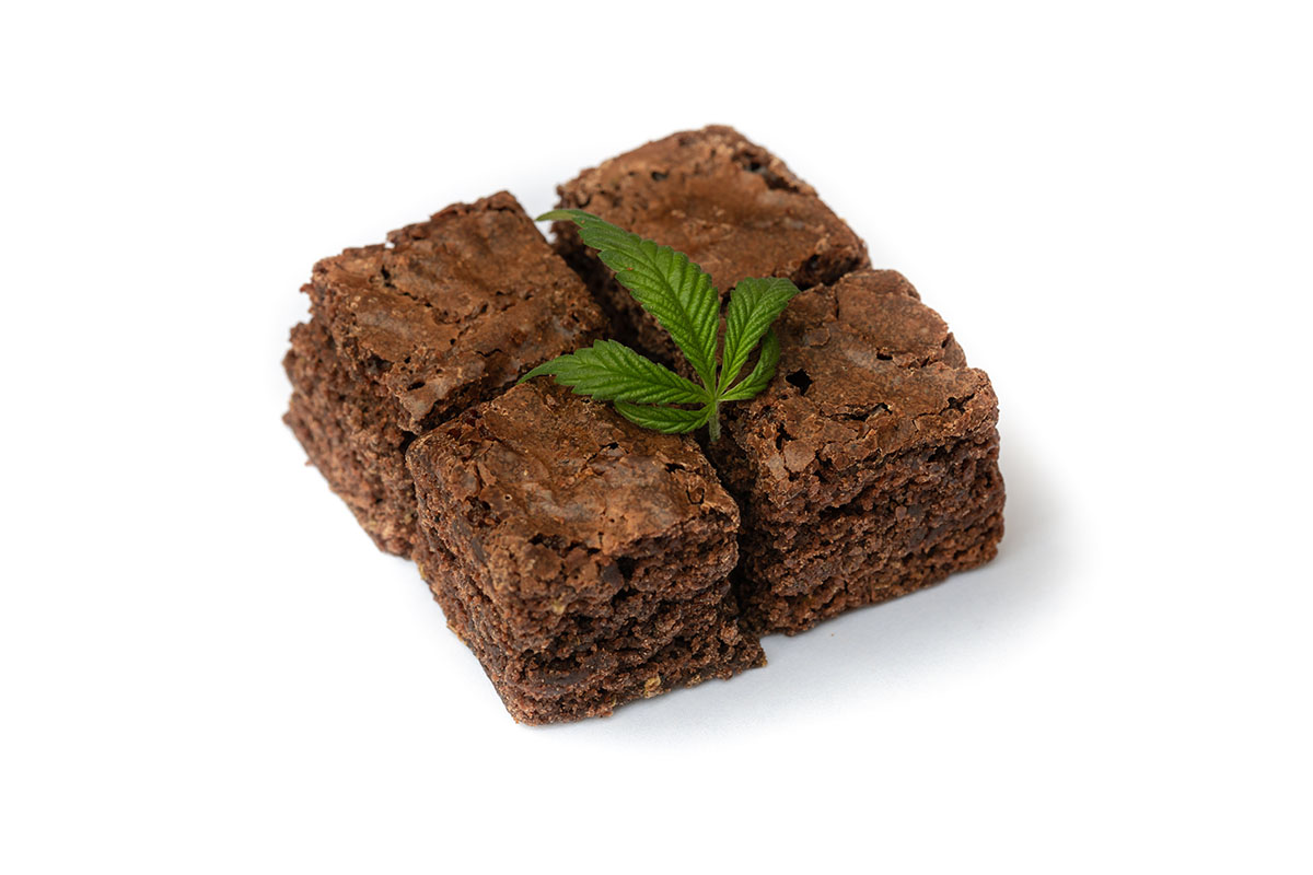 Brownie cut into four pieces with a cannabis bud on top
