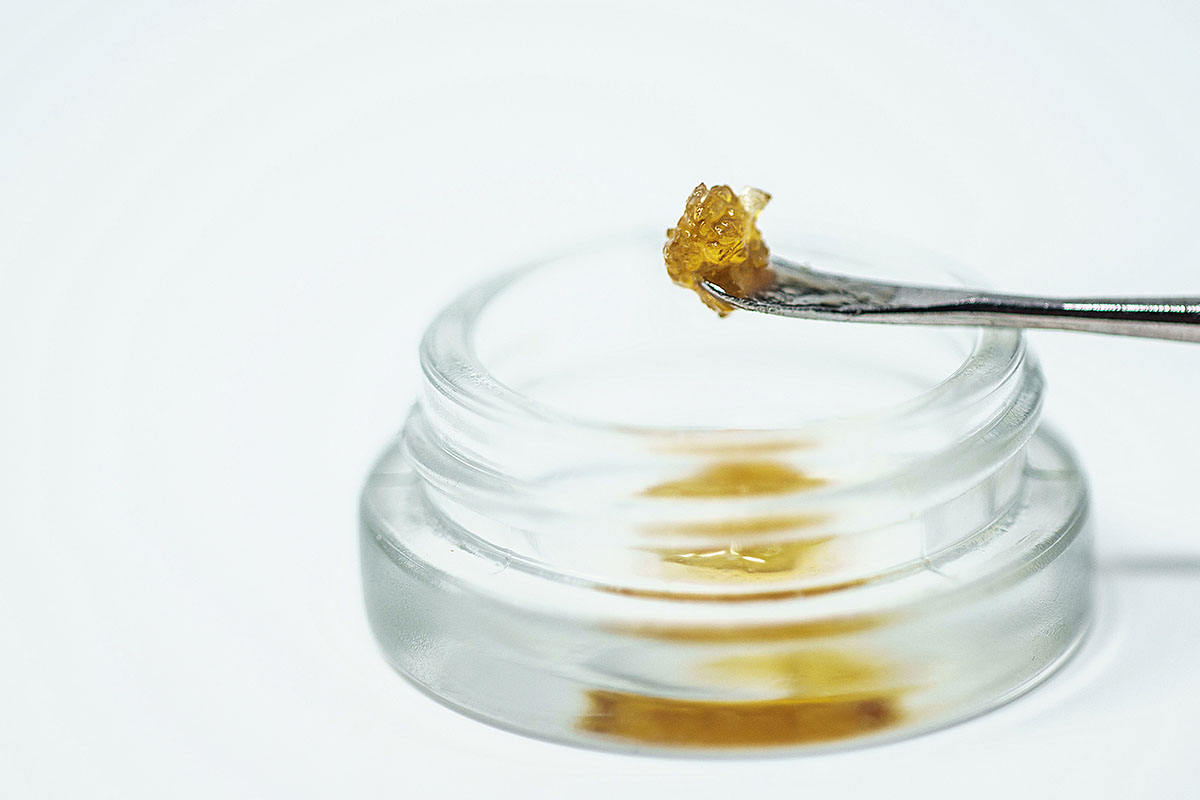 THCA diamonds being scooped out of a glass jar