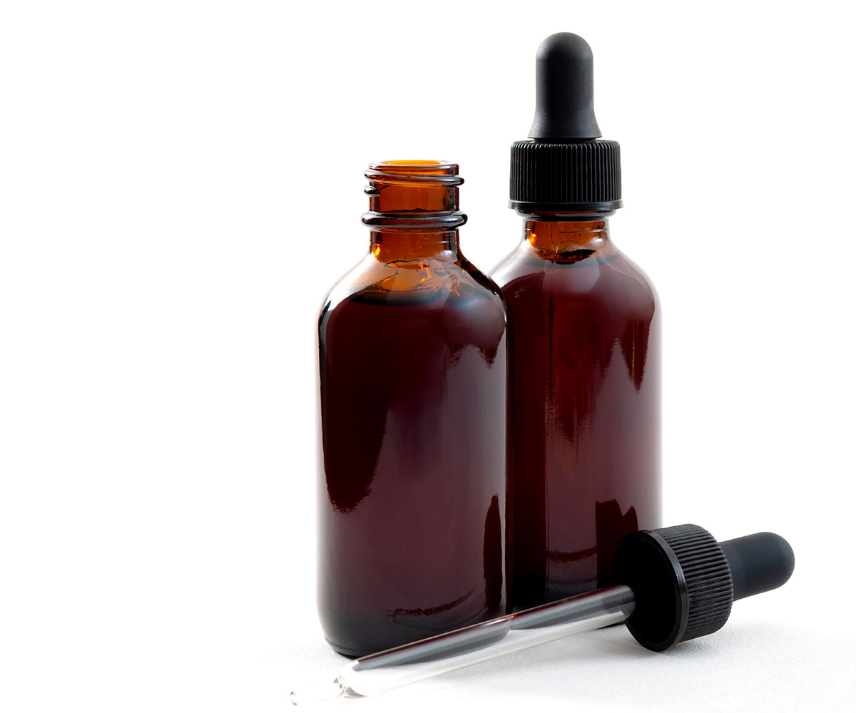 Two opaque tincture bottles, one with the dropper sitting next to it