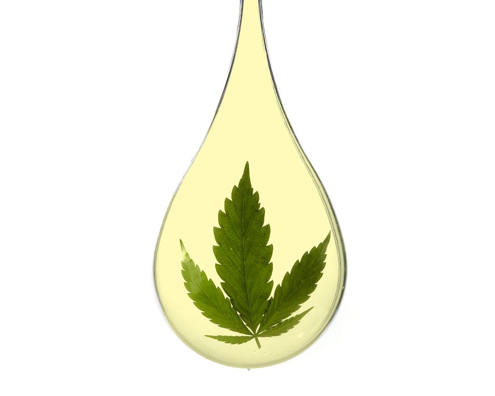 Yellow tinted water droplet with a cannabis leaf floating inside